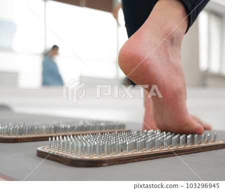 A woman comes down from the sadhu boards. Close-up of feet with prints after nails.  103296945