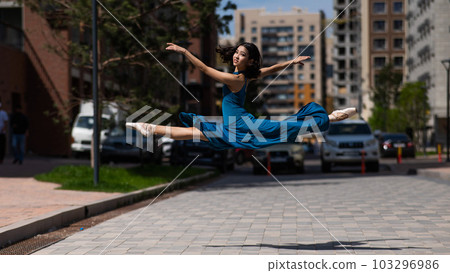 Beautiful Asian ballerina dancing outdoors. Urban landscape. Grand jete.  Beautiful Asian ballerina dancing outdoors. Urban landscape. Grand jete.  103296986