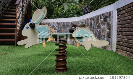 Bunny swing metal spring or spring rider at the children playground. 103297804