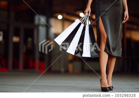 Shopping bags in the hands. Fashion woman with packages after shopping. Black friday, sale. Shopping bags in the hands. Fashion woman with packages after shopping. Black friday, sale. 103298328