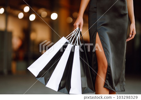 Shopping bags in the hands. Fashion woman with packages after shopping. Black friday, sale. Shopping bags in the hands. Fashion woman with packages after shopping. Black friday, sale. 103298329