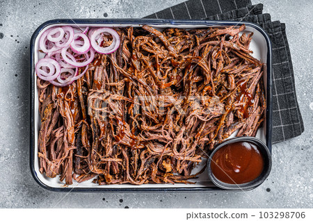 Pulled beef meat with hot chili sauce in baking dish. Gray background. Top view 103298706