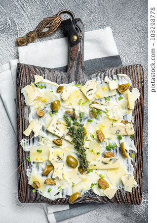 Butter board with herbs, blue cheese, capers, parmesan and olives, Butterboard. White background. Top view Butter board with herbs, blue cheese, capers, parmesan and olives, Butterboard. White background. Top view 103298778