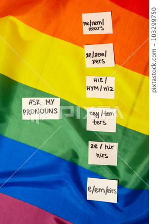 ASK MY PRONOUN Neo pronouns concept. Rainbow flag with paper notes text gender pronouns hie, e, ne, xe, ze, tey. Non-binary people rights transgenders. Lgbtq community support assume my gender 103299750