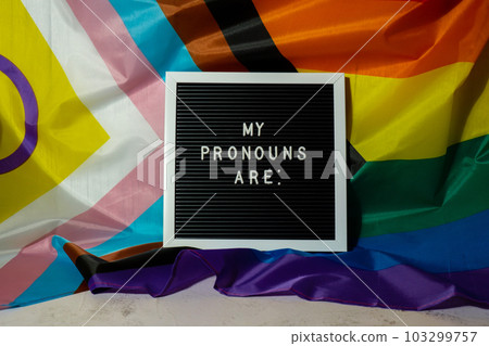 MY PRONOUNS ARE text Neo pronouns concept on Rainbow flag background gender pronouns. Non-binary people rights transgenders. Lgbtq community support assume my gender tolerance equal rights MY PRONOUNS ARE text Neo pronouns concept on Rainbow flag background gender pronouns. Non-binary people rights transgenders. Lgbtq community support assume my gender tolerance equal rights 103299757