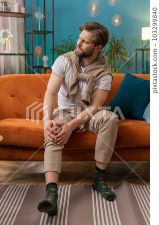 Young Caucasian man suffer from painful severe knee joint ache leg muscles illness cramps rheumatism Young Caucasian man suffer from painful severe knee joint ache leg muscles illness cramps rheumatism 103299840