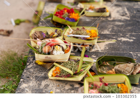 The layout on the ground of traditional offerings for the spirits on the island of Bali. 103302355