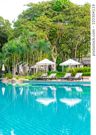 Umbrella and chair around swimming pool in hotel resort Umbrella and chair around swimming pool in hotel resort 103304119