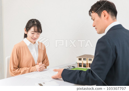 一位女士和一位商人一邊查看藍圖和圖紙,一邊諮詢房屋的改造和翻新 一位女士和一位商人一邊查看藍圖和圖紙,一邊諮詢房屋的改造和翻新 103307707