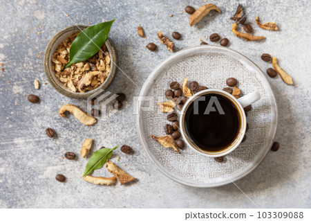 Healthy organic energizing adaptogen, trendy drink. Mushroom coffee in a cup with coffee beans. View from above. Healthy organic energizing adaptogen, trendy drink. Mushroom coffee in a cup with coffee beans. View from above. 103309088