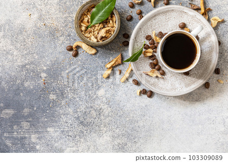 Healthy organic energizing adaptogen, trendy drink. Mushroom coffee in a cup with coffee beans. View from above. Copy space. Healthy organic energizing adaptogen, trendy drink. Mushroom coffee in a cup with coffee beans. View from above. Copy space. 103309089