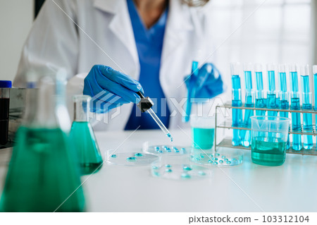 Scientist mixing chemical liquids in the chemistry lab. Researcher working in the chemical laboratory 103312104
