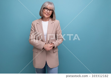 smiling middle-aged woman in a stylish jacket smiling on a bright studio background 103312182