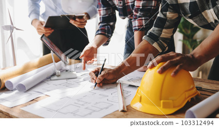 Engineer teams meeting working together wear worker helmets hardhat on construction site in modern city. industry professional team in office. 103312494