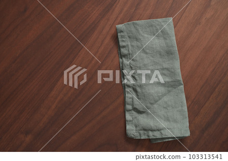 walnut wood table with green linen napkin walnut wood table with green linen napkin 103313541