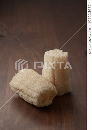 Organic loofah bath scrub on walnut table 103313682