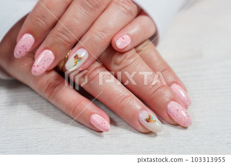 Women's manicure in pink, close-up. A woman's hand with a beautiful pink manicure. 103313955