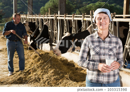 Confident female milker with milk on dairy farm Confident female milker with milk on dairy farm 103315398