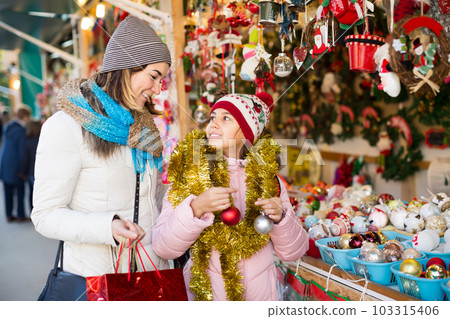 young mother with little daughter buying decorations for Xmas young mother with little daughter buying decorations for Xmas 103315406