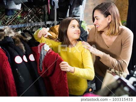 Mother and girl buying warm sweater 103315433