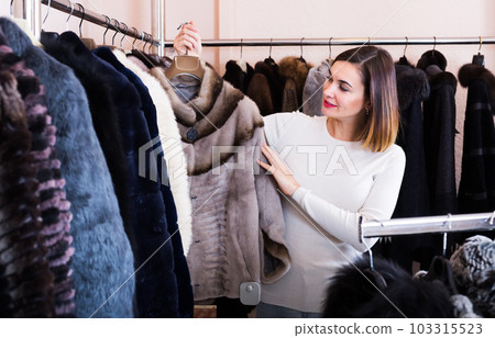 Girl deciding on fur jacket Girl deciding on fur jacket 103315523