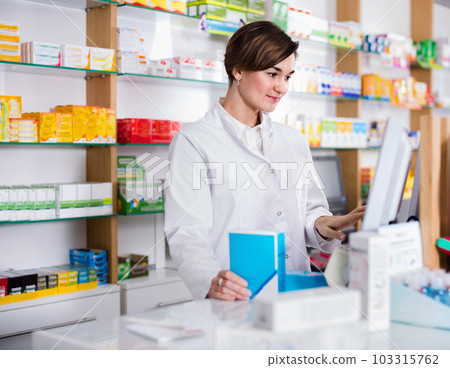 Female pharmacist offering help in choosing at counter in pharmacy Female pharmacist offering help in choosing at counter in pharmacy 103315762