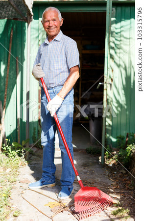 Man working with garden rake 103315796