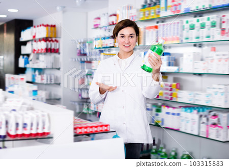 Positive female pharmacist offering products 103315883