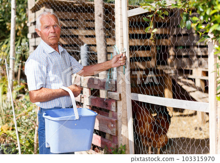 Older man near henhouse 103315970