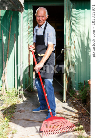 Man working with garden rake 103315971
