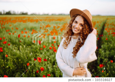 Young woman walking in amazing poppy field. Nature, vacation, relax and lifestyle. Young woman walking in amazing poppy field. Nature, vacation, relax and lifestyle. 103316027