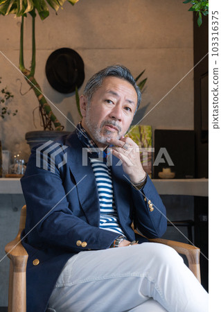 Portrait of a middle-aged man sitting on a chair Vertical position 103316375