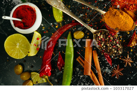 different spices and aromatic herbs on a dark table. View from above. different spices and aromatic herbs on a dark table. View from above. 103317027