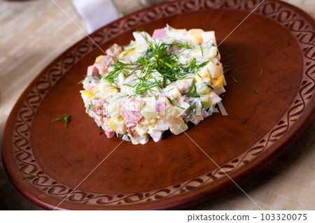 salad with peas and mayonnaise, served in a cylinder on a clay plate salad with peas and mayonnaise, served in a cylinder on a clay plate 103320075