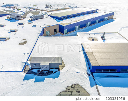 Elevated overhead drone view of a flat roofed building with snow load and ventilation units. 103321956