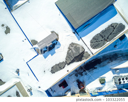Elevated overhead drone view of a flat roofed building with snow load and ventilation units. 103322055