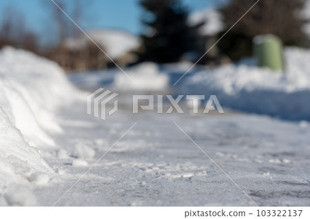 Selective focus ground level view of snow blown sidewalk section with path continuing. Selective focus ground level view of snow blown sidewalk section with path continuing. 103322137
