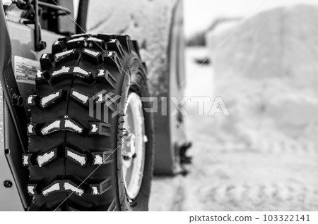 Selective focus on snowblower tires with a defocused drift of snow in background.. Selective focus on snowblower tires with a defocused drift of snow in background.. 103322141