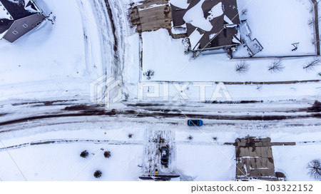 Aerial drone overhead view of a city street and plowed in residential driveway. Aerial drone overhead view of a city street and plowed in residential driveway. 103322152