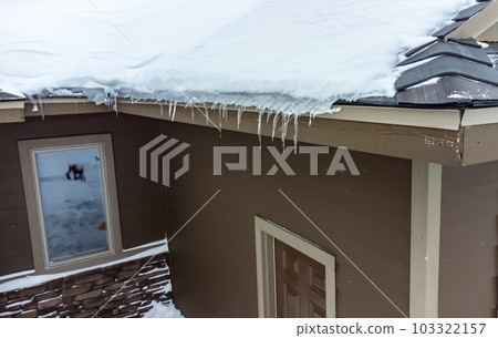 Elevated view of an ice dam and snow on a residential roof.  103322157