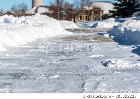 Selective focus ground level view of snow blown sidewalk section with path continuing. Selective focus ground level view of snow blown sidewalk section with path continuing. 103322225