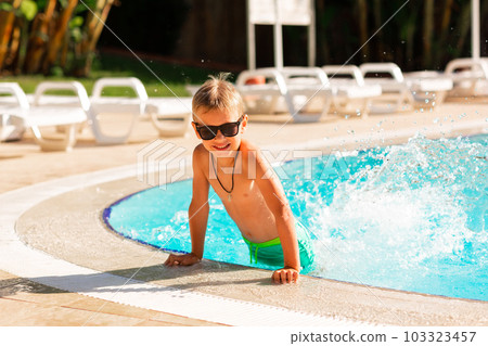 Happy little boy having fun at the pool at the resort Happy little boy having fun at the pool at the resort 103323457