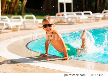 Happy little boy having fun at the pool at the resort 103323458