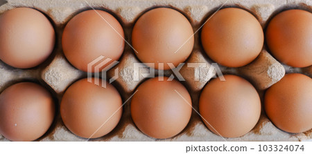 Close up group of organic eggs in brown carton box on wooden background. Close up group of organic eggs in brown carton box on wooden background. 103324074