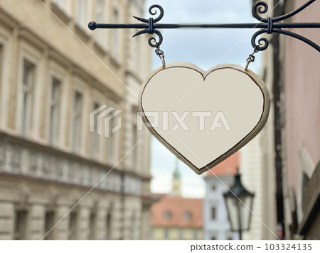 blank heart shape hanged over blurred city view 103324135
