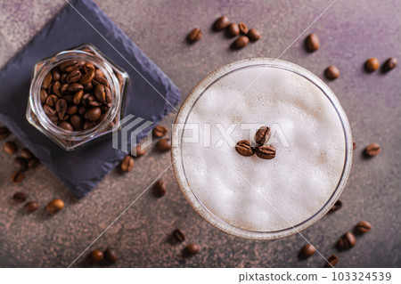 Close up of cold martini espresso cocktail in glasses and coffee beans on the table top view Close up of cold martini espresso cocktail in glasses and coffee beans on the table top view 103324539