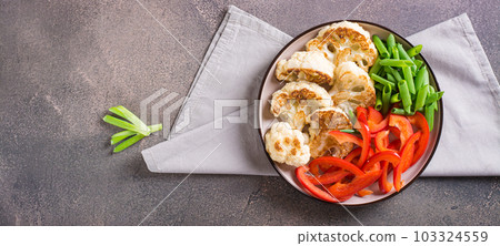 Roasted cauliflower, bell peppers and chives in a veggie bowl top view web banner Roasted cauliflower, bell peppers and chives in a veggie bowl top view web banner 103324559