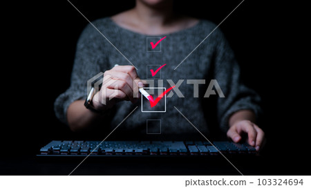 Businesswomen checking mark on checklist with a red checkmark. online checklist survey, filling out digital form checklist. take an assessment, questionnaire, evaluation, online survey, online exam. 103324694