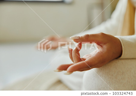 Closeup of young woman hand while sitting in lotus position and meditating. 103324743