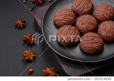 Delicious sweet chocolate cookies on a black ceramic plate Delicious sweet chocolate cookies on a black ceramic plate 103324856